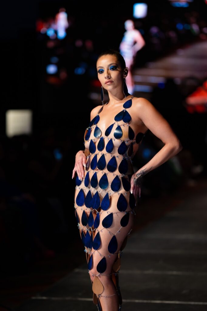 SWAIA Native Fashion Week 8 TABLE Magazine A woman in a raindrop dress walks down a runway.