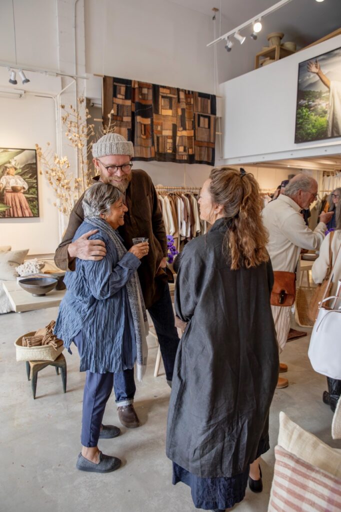 Spring Launch Party 10 TABLE Magazine A man in a beanie hugs a shorter woman with grey hair.