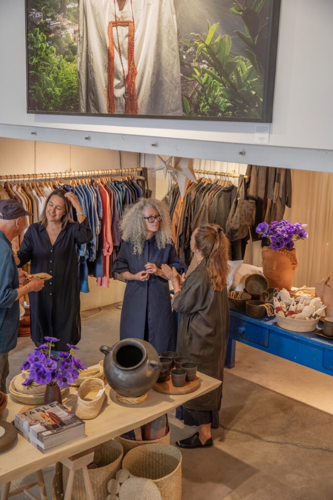Spring Launch Party 12 TABLE Magazine Four people talk in front of racks of clothing.