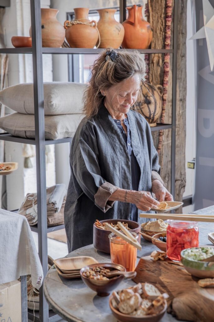 Spring Launch Party 14 TABLE Magazine A woman picks up snacks from a table.