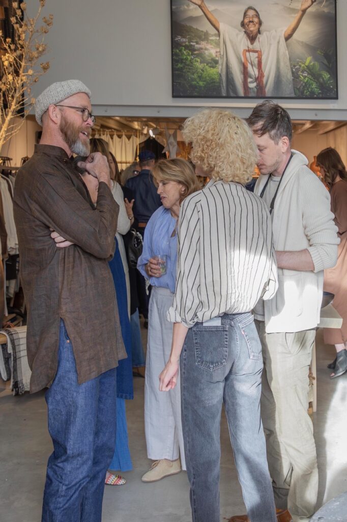 Spring Launch Party 21 TABLE Magazine Three people talk in a large space.