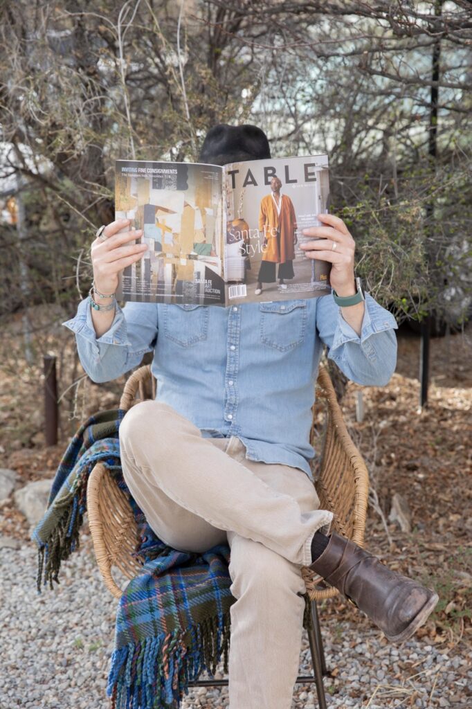 Spring Launch Party 22 TABLE Magazine A man looks through TABLE Magazine in a brown wicker chair.