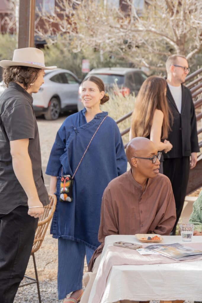 Spring Launch Party 23 TABLE Magazine People stand and talk as others sit at a white table outside.