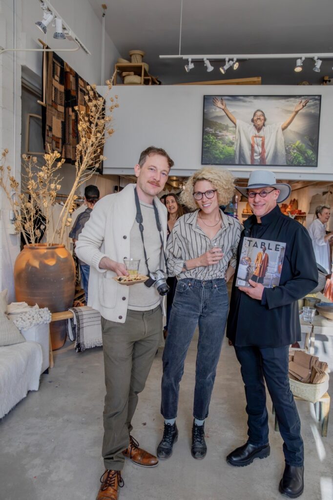 Spring Launch Party 25 TABLE Magazine Two men and a woman pose together with drinks and magazines.