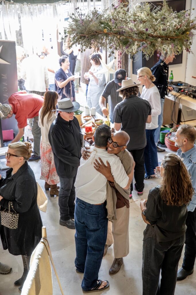 Spring Launch Party 28 TABLE Magazine People hug in a room full of others.