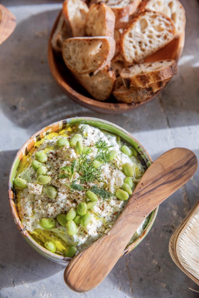 Spring Launch Party 3 TABLE Magazine A green bean dip in a bowl next to sliced bread.