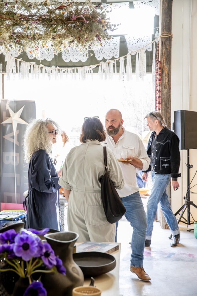Spring Launch Party 30 TABLE Magazine Three people talk together on a dance floor area.