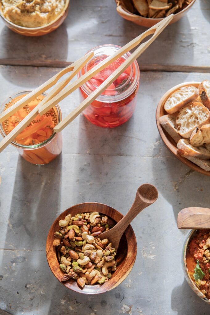 Spring Launch Party 4 TABLE Magazine A small bowl of nuts sits in front of jars of fermented veggies.