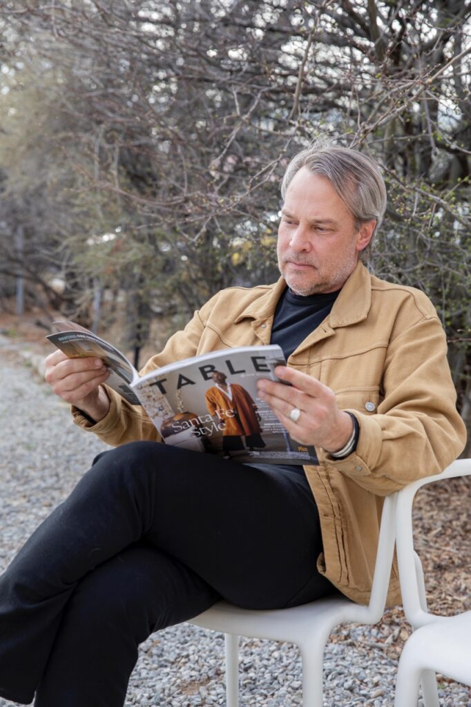 Spring Launch Party 8 TABLE Magazine A man sits in a white chair reading TABLE Magazine.