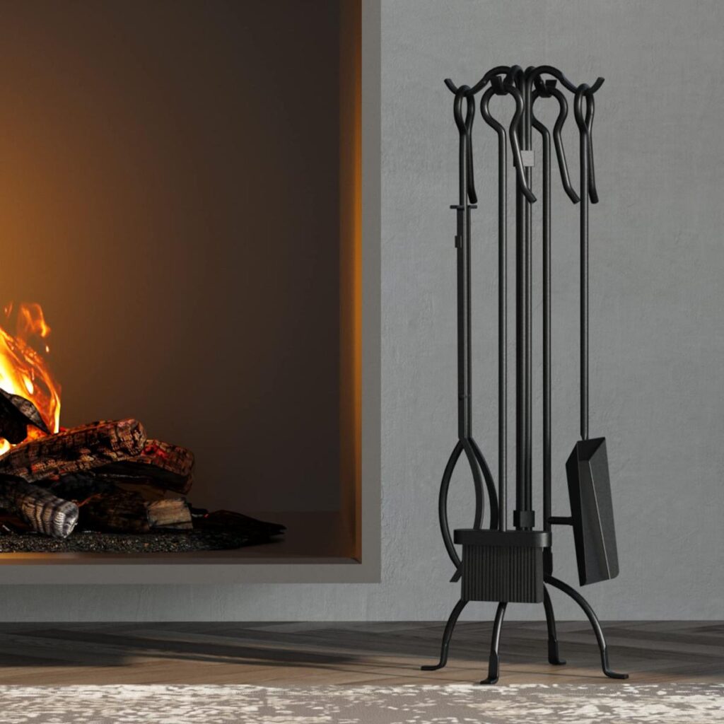 A fireplace tool set, with a stand and four tools, is standing next to a lit fireplace.