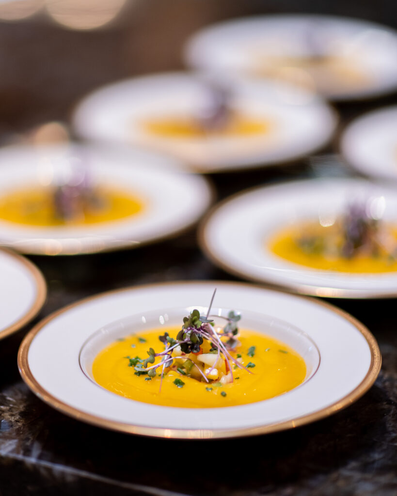 white bowls on black table with yellow soup