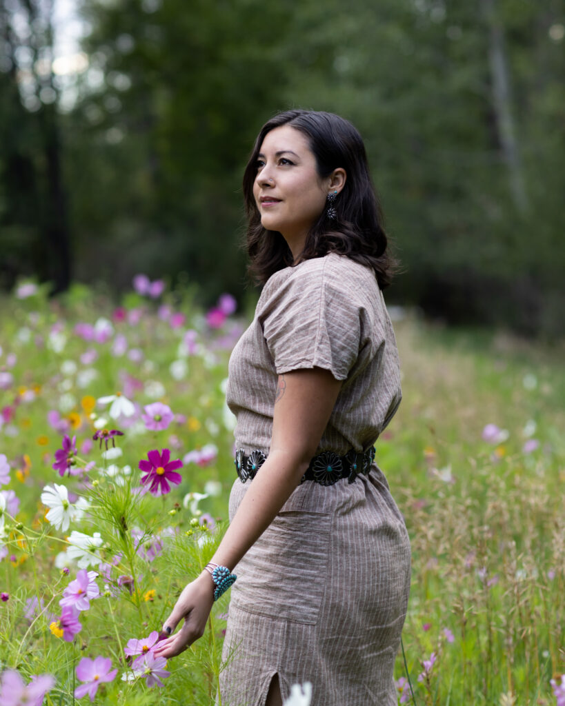 woman in flower field looking to the side wearing brown dress