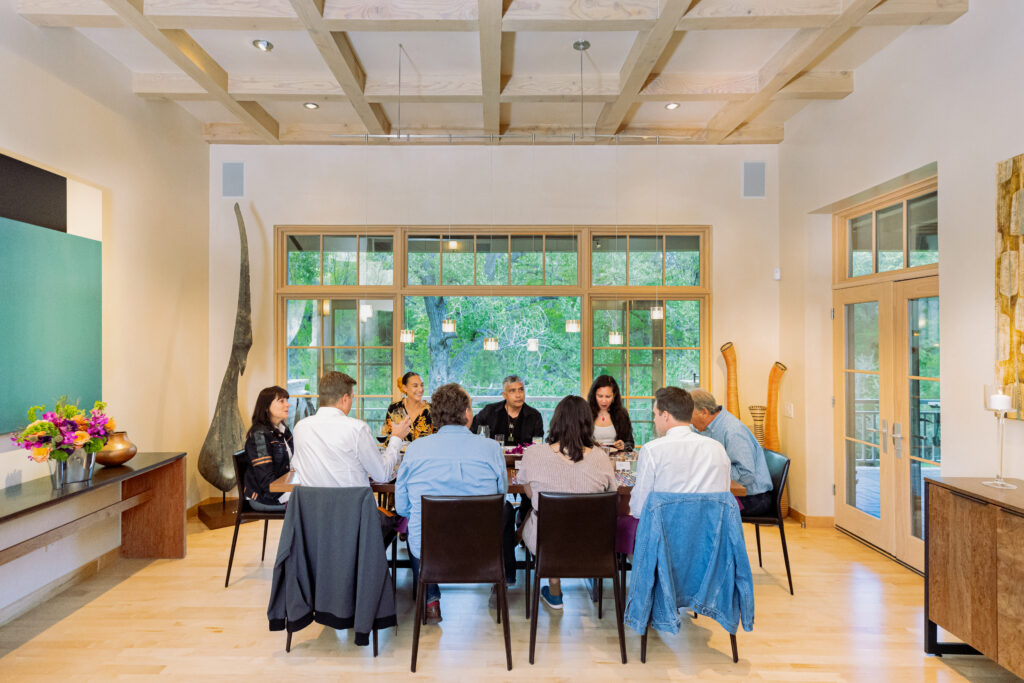 group sitting around dinner table in bright room