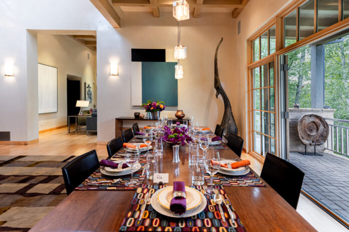 large brown dinner table with plating set up