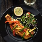 Wild-Caught Alaskan Salmon on black plate with greens.