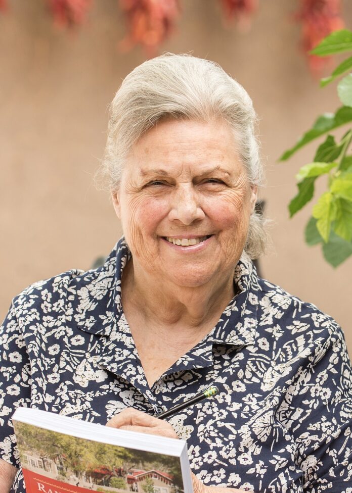 Florence Jaramillo TABLE Magazine 5 Florence Jaramillo smiles outside holding a book up to her chest.