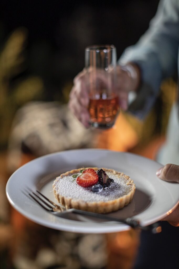 A small mixed berry tart on a white plate.