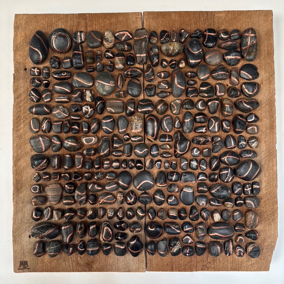 A series of small pebbles on a wood table.