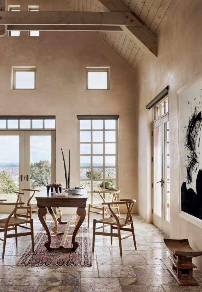 bright sitting area with tan walls and stone flooring with wooden table and chairs