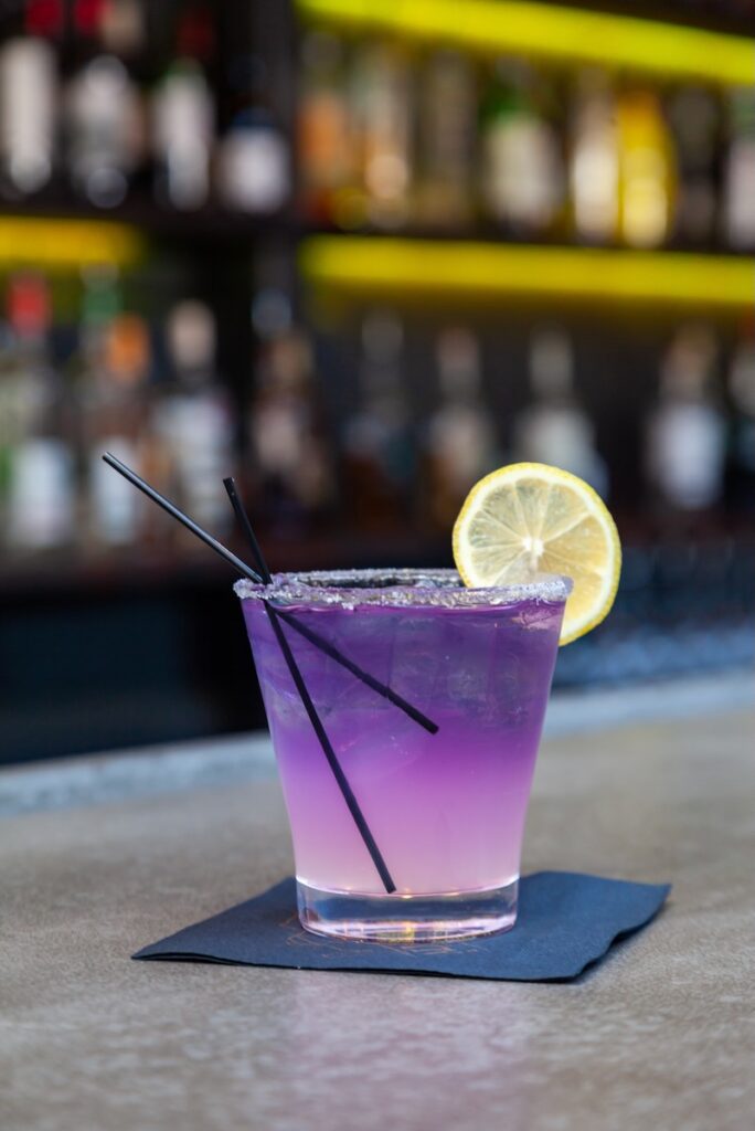 Purple cocktail yellow garnish