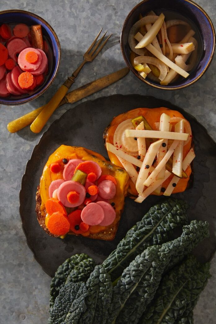 Vegetable Escabeche Vegetable Escabeche on toast on a black plate.