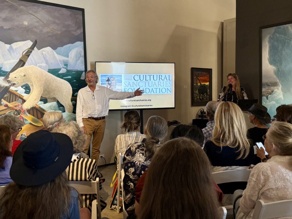 International Folk Art Market 2025 TABLE Magazine A man presents in front of a seated crowd.