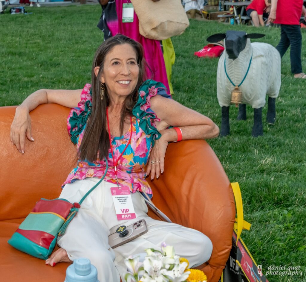 International Folk Art Market 2025 TABLE Magazine 8 A woman lounges in an orange bean bag chair.