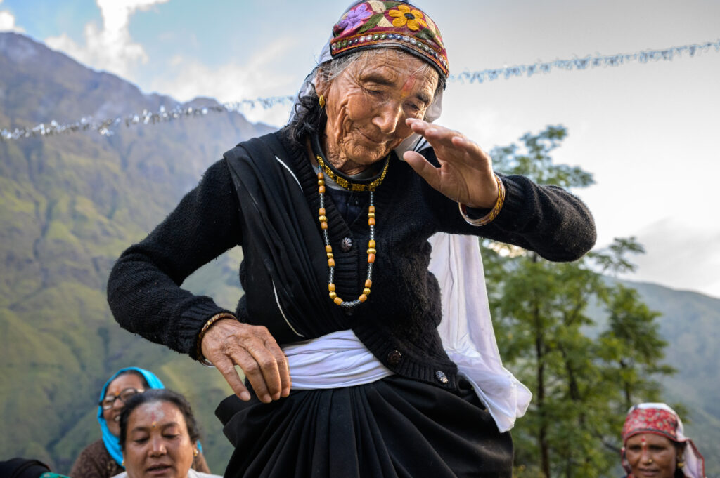 woman in black dress holding up hands in traditional ceremony