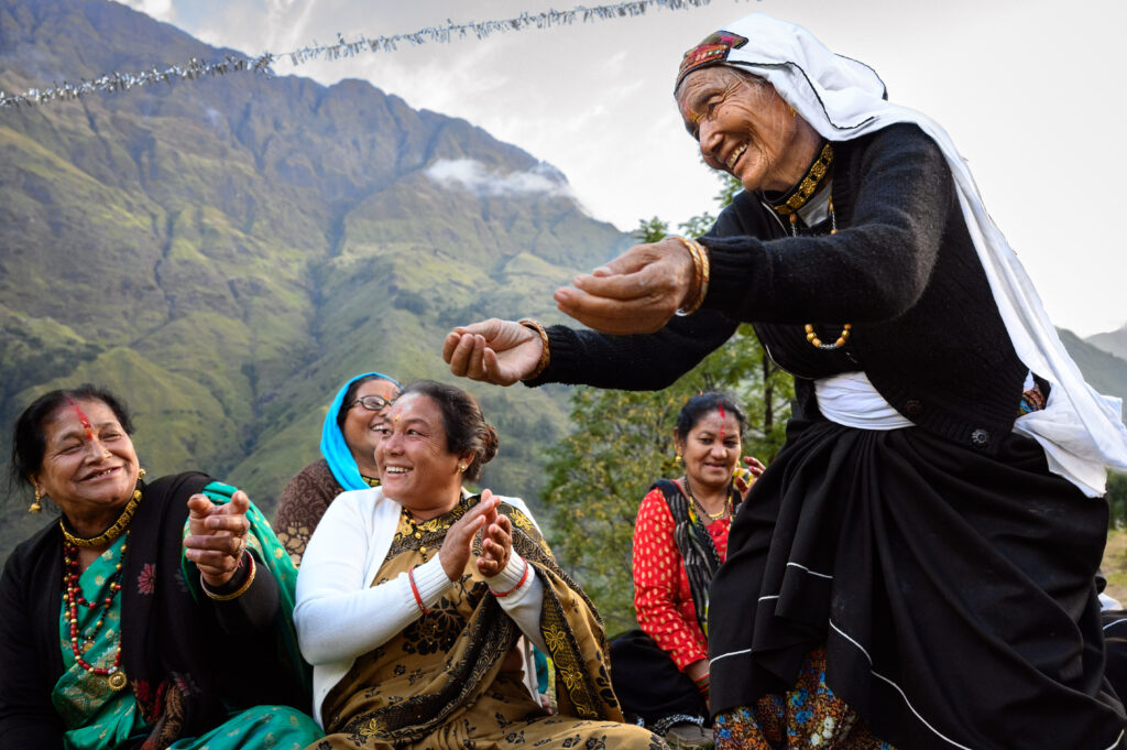 woman holding out her hands in mountains to other women