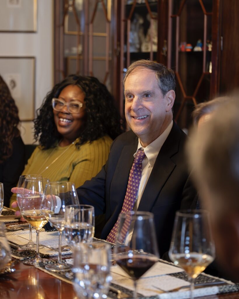 A man in a tie sits at a dining table.