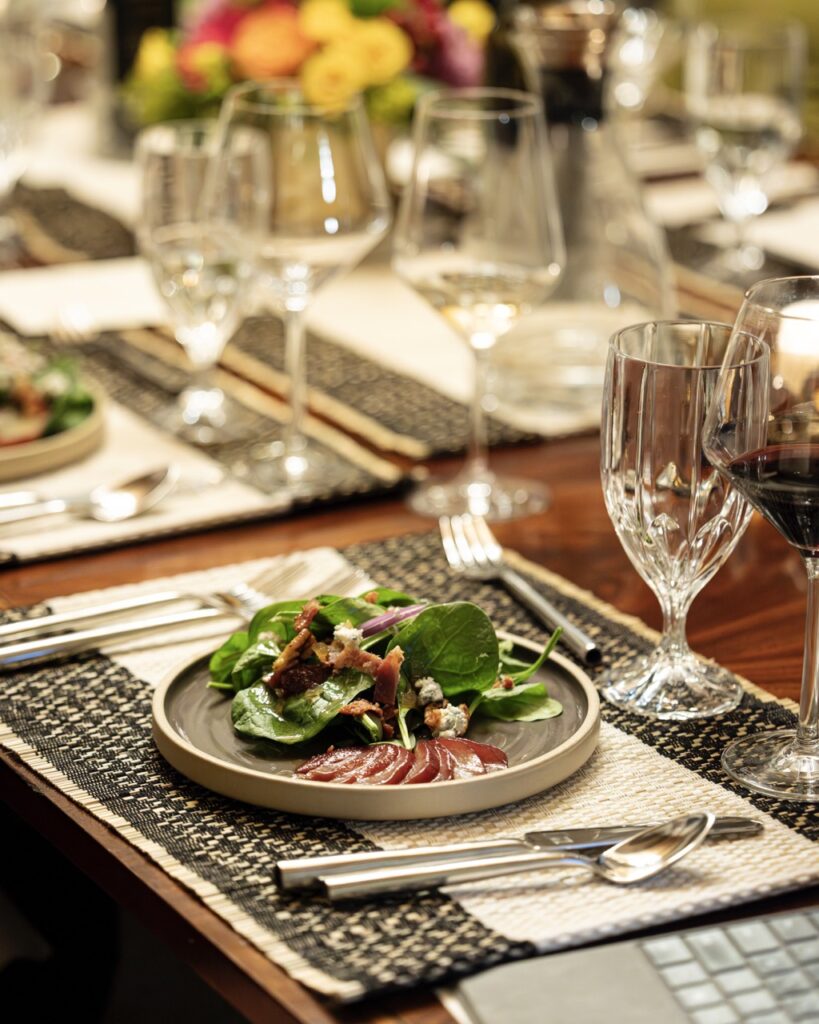 A plate with a salad on a dining table placemat.