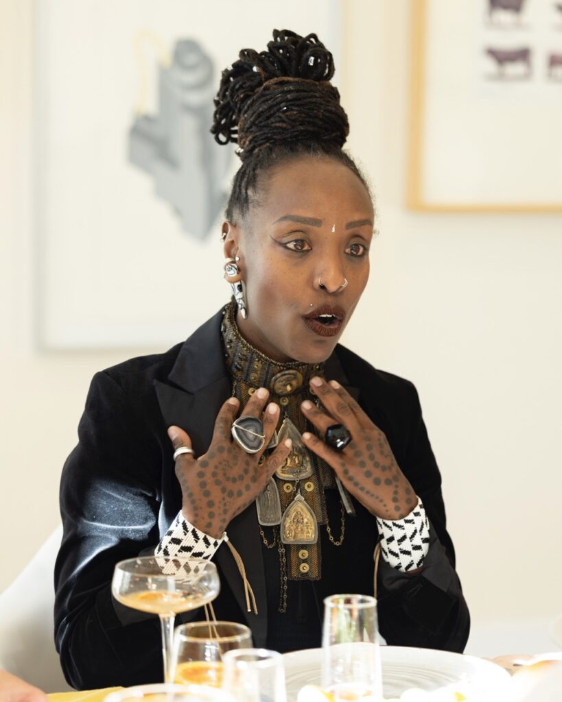 A woman in a black jacket sitting at a dinner table.