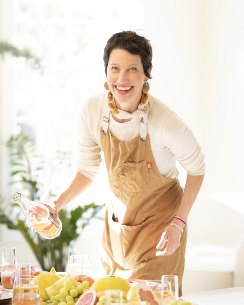 A woman in a tan apron in the sunlight.