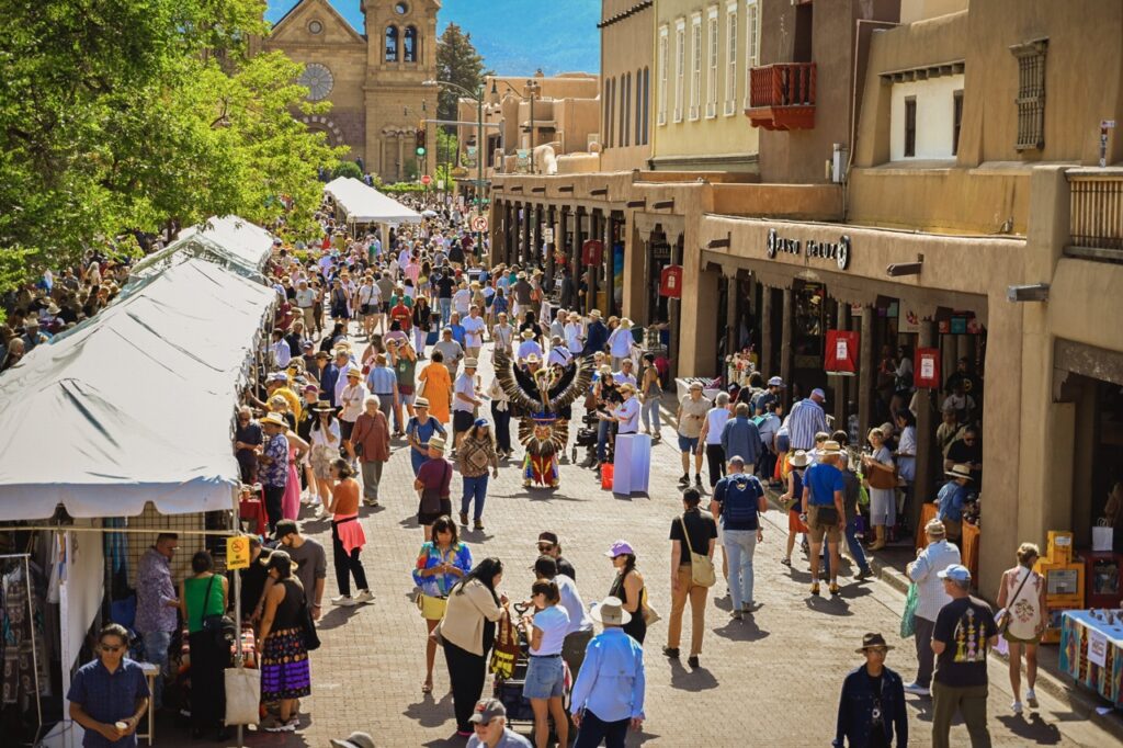 2025 Indian Market Santa Fe New Mexico. People walking through the Indian Market in Santa Fe on a brick road.