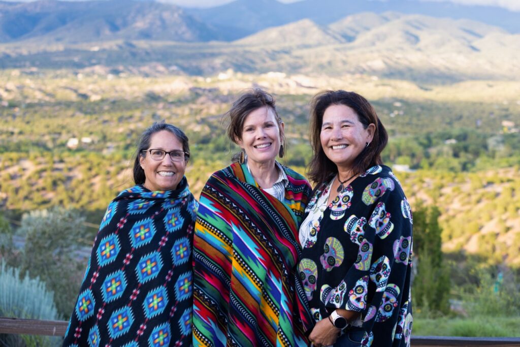 Audience Experience Portrait Series July 2 2025 Santa Fe Opera Three women in colorful ponchos stand in front of a mountain range.