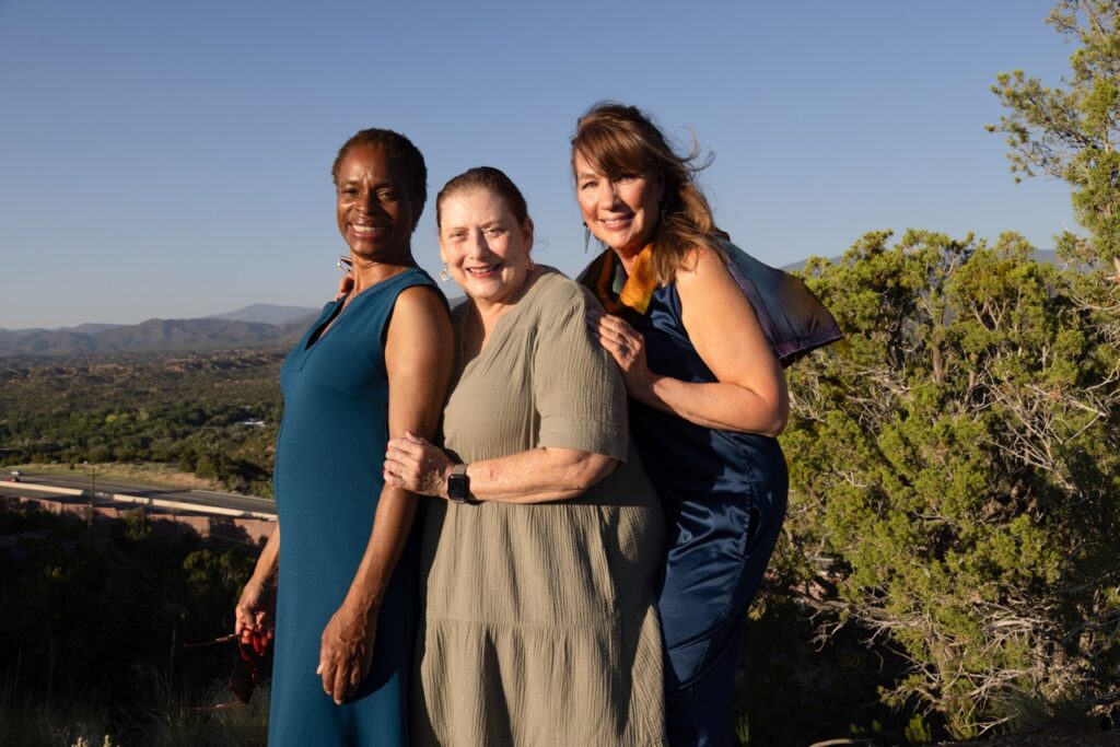 Audience Experience Portrait Series July 4 2025 Santa Fe Opera Three women stand together in long dresses in front of a mountain range.