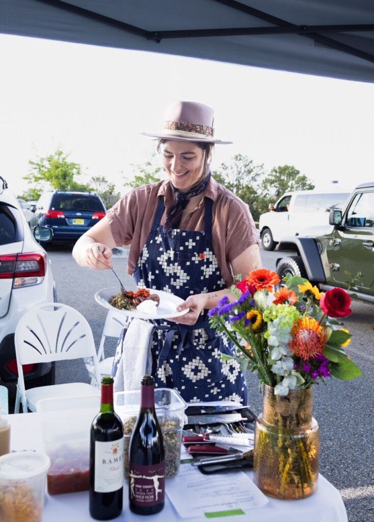 Audience Expeirence Portrait Series June 27 2025 Santa Fe Opera A woman dishes out food on to a paper plate.