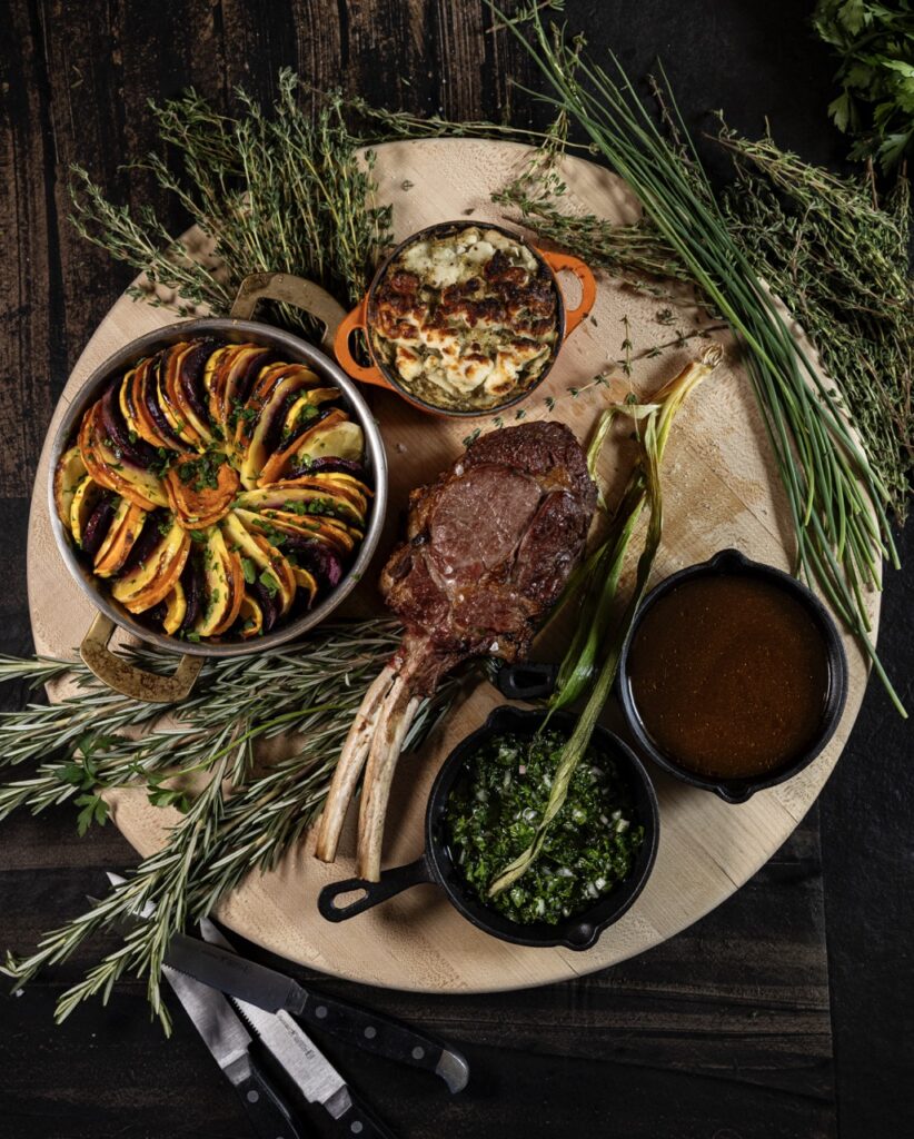 A white plate full of veal chops and various herbs.