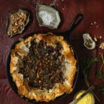 Chard and Feta Pie in a skillet with things around it