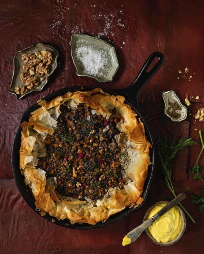 Chard and Feta Pie in a skillet with things around it