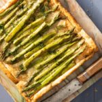 A rectangular Asparagus Tart with stalks of asparagus lined on top of the pastry.