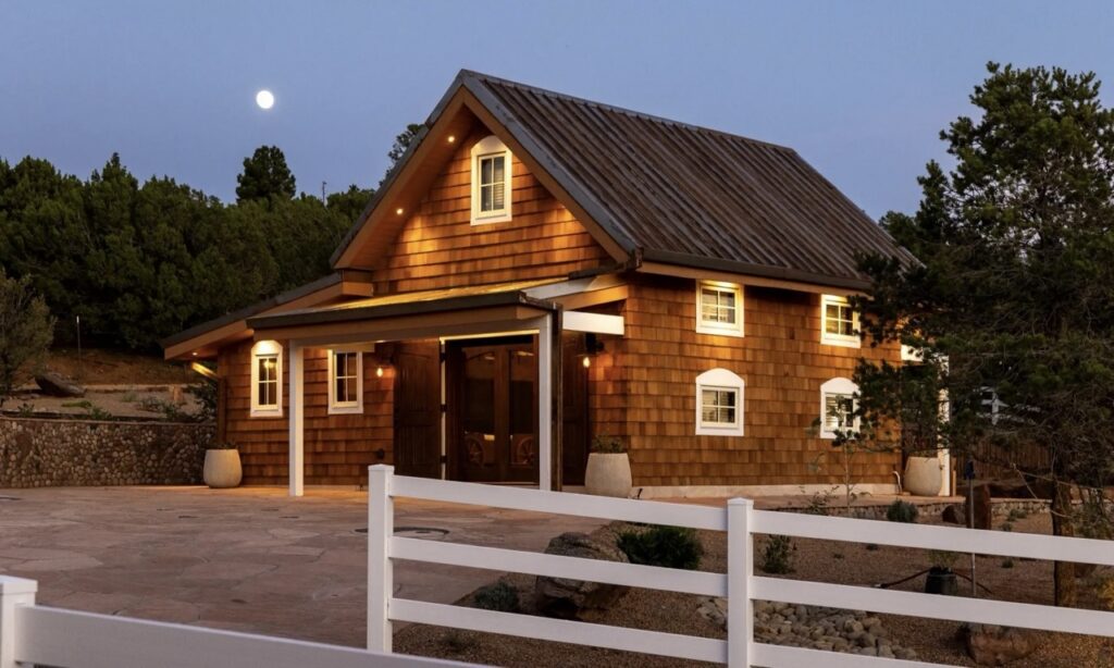 A photo of a home set in the mountains just before dusk.
