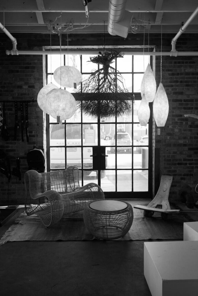 A store space with low-hanging lamps and various unique furniture items.