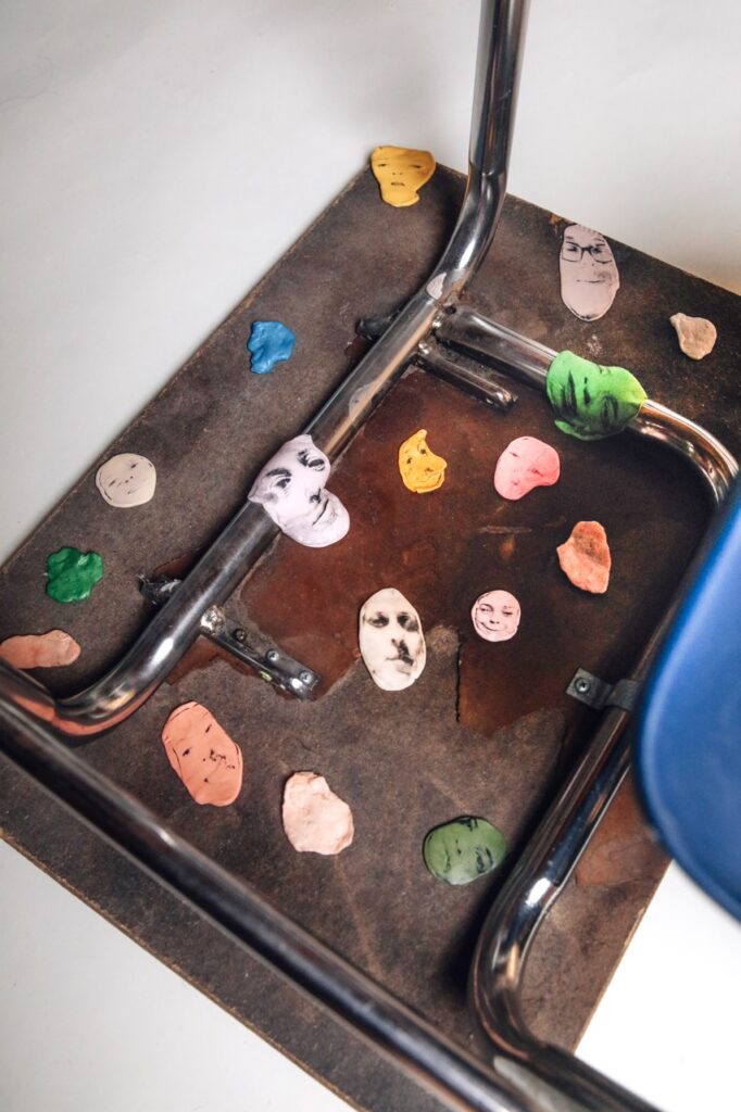 Pieces of gum under a desk are painted like faces.