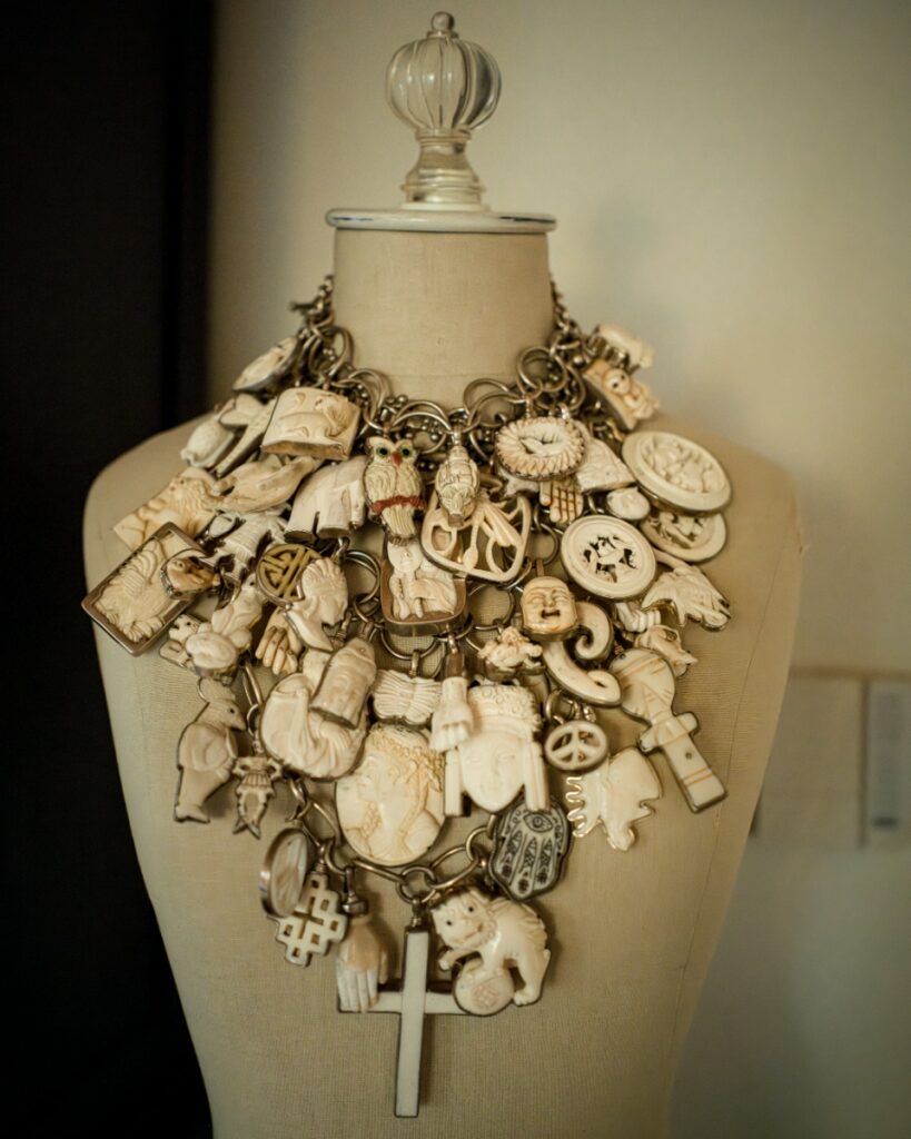 A collection of colorful Mexican alebrijes woodcarvings, including rabbits and fantastical creatures, displayed on a purple shelf in Coreen Cordova's home.