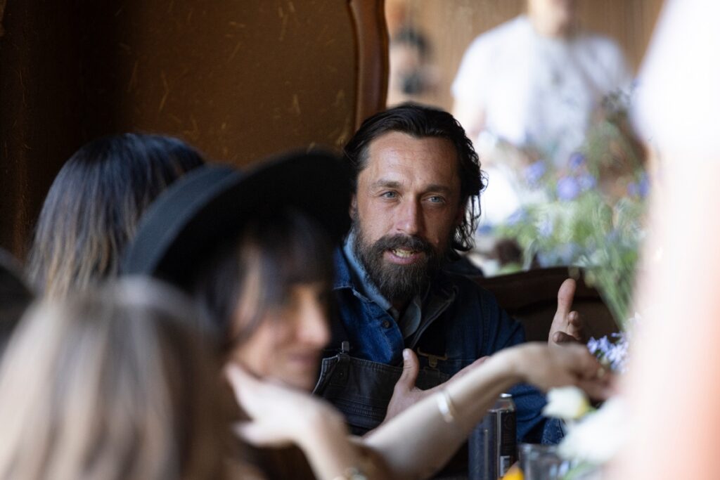 Jared Hagood of Lineage Seeds speaking with guests at a dinner party.