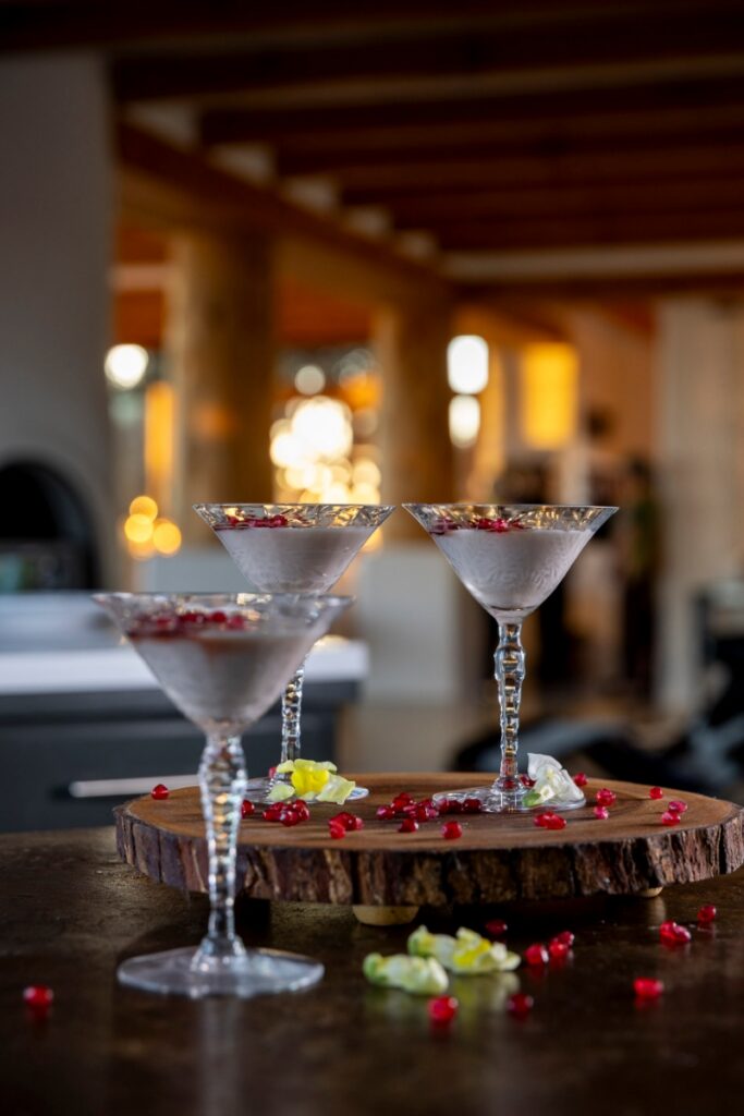 Manjar Blanco, a medieval Sephardic almond milk pudding garnished with pomegranate seeds, served in crystal glasses for a Passover Seder.
