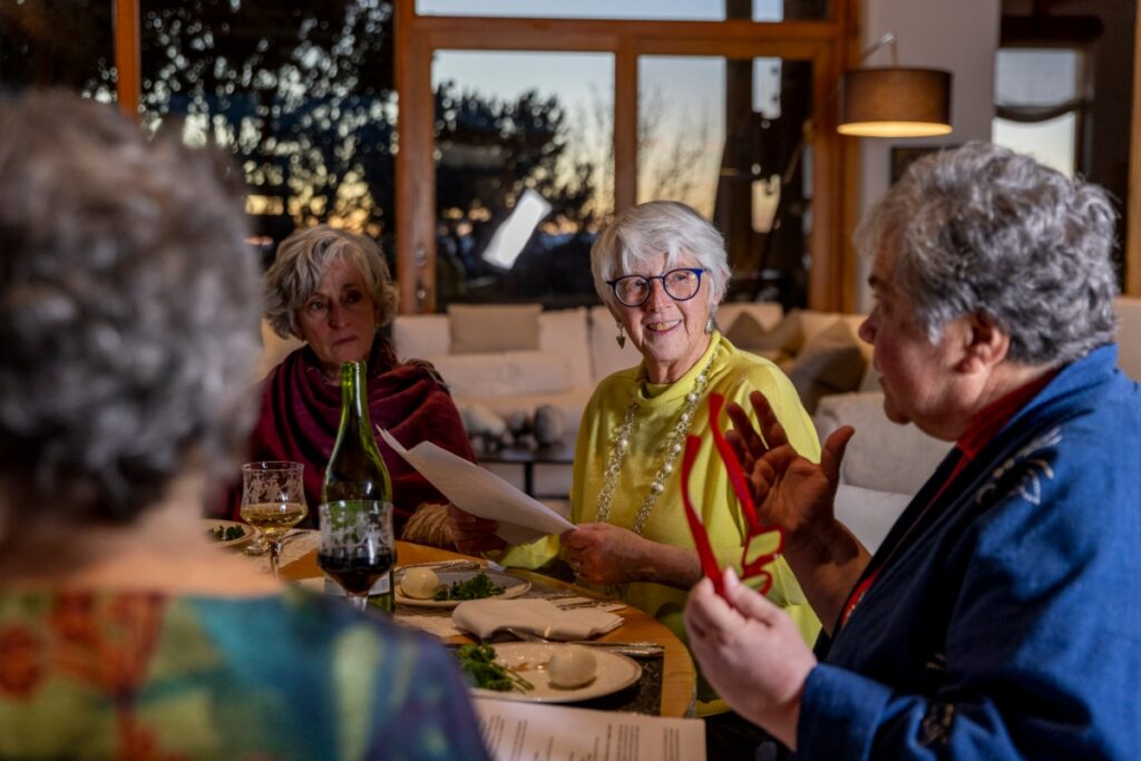 Jill Heppenheimer and Rabbi Carolyn Silver leading a Passover Seder discussion with friends over a traditional meal in Santa Fe.