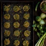 A picture of small Passover crackers in a muffin tin beside fresh produce.