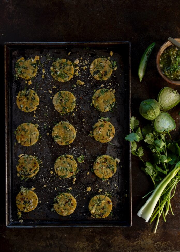 A picture of small Passover crackers in a muffin tin beside fresh produce.